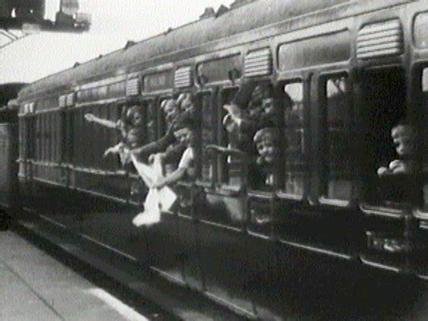 Archival image of children waving from a train in A Rough Crossing